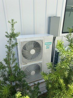 Dual-fan outdoor condenser installed beside residential siding — Affordable Air Service