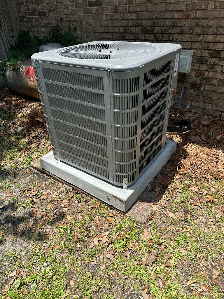 Residential condenser on a concrete pad at an Emerald Coast home — Affordable Air Service