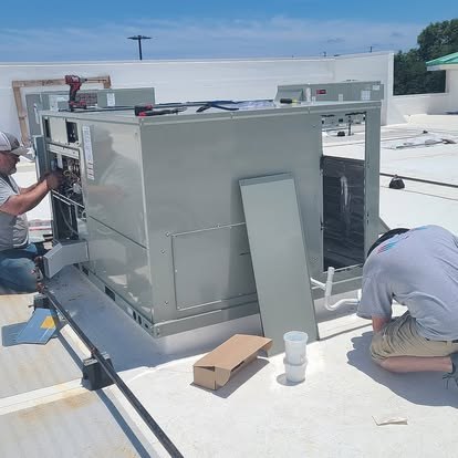 Technicians working a commercial rooftop HVAC unit — Affordable Air Service