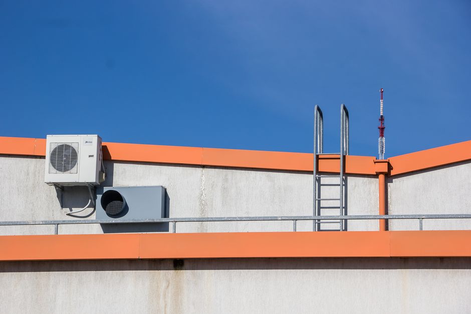 Blog 2 A comparison showing a bulky, old-fashioned cube HVAC unit next to a sleek, slim Daikin Fit outdoor unit