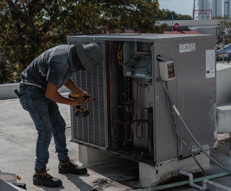 Blog 1 AC technician servicing outdoor unit in humid coastal Florida heat